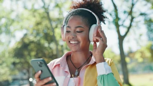 Outdoor, phone and woman with headphones for walk in park listening to music online in nature