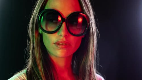 Stylish Woman Posing in Round Sunglasses with Colored Lights