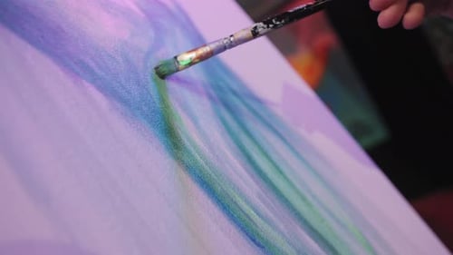 Paintbrush Applying Green Paint to an Abstract Painting