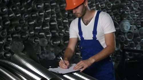 Man in uniform works on the production. Industrial modern technology