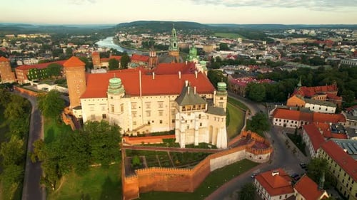 Beautiful golden sun lighting on ancient Wawel Royal Castle with Vistula River in background at sunr