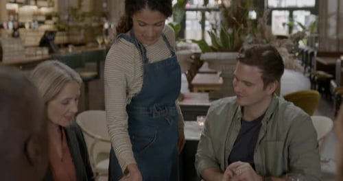 Waitress Serving Food in Restaurant to Family