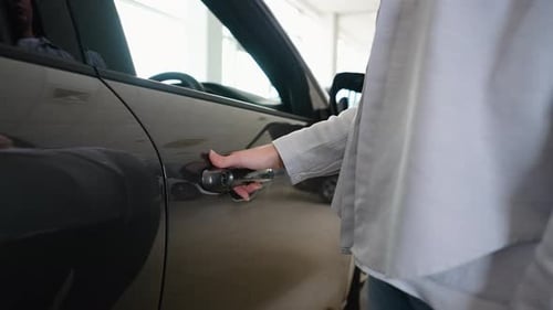 Close Up of a Female Hand Opening a New Car Door in Car Dealership Right Hand Drive Car
