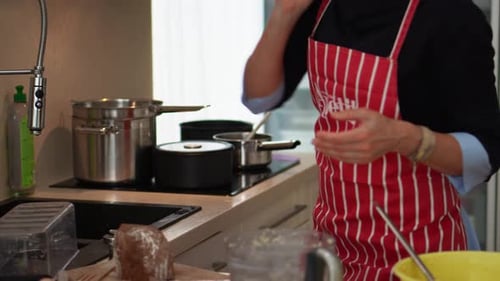 Woman Wearing Apron Is Busy Cooking Inside The Home Kitchen. Medium Shot