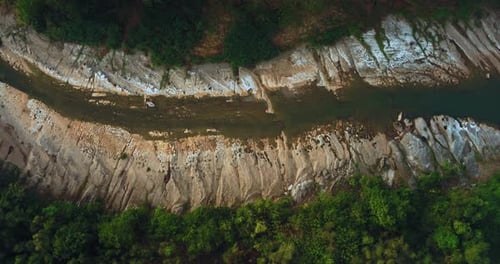Aerial sunrise over winding river surrounded by misty tropical forest