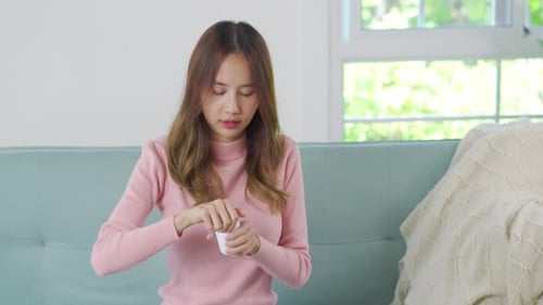 Woman Taking Pills From White Medicine Bottle