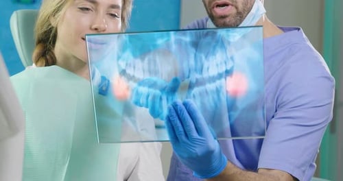 Un dentiste futuriste montre la plaque holographique futuriste de la dentition de la patiente, et elle