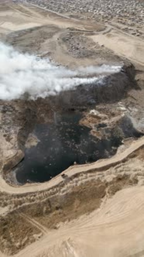 Aerial view of landfill with burning trash piles