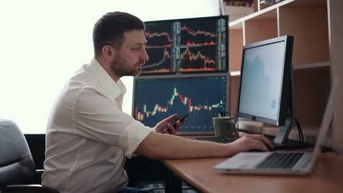 Der Börsenmakler im weißen Hemd arbeitet in einem Überwachungsraum mit Bildschirmen.
Börse