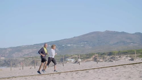 Excited Man and Woman Chasing Each Other on Path on Ocean Shore