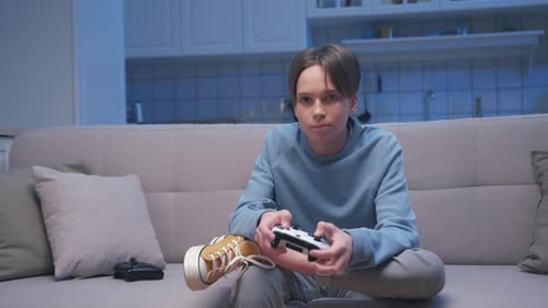 Young Boy Playing Video Console with Gamepad Joystick Controller and Losing Game