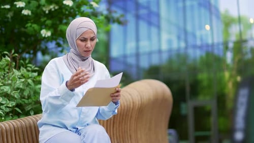 Woman Reads Distressing News Outside Modern Office Building