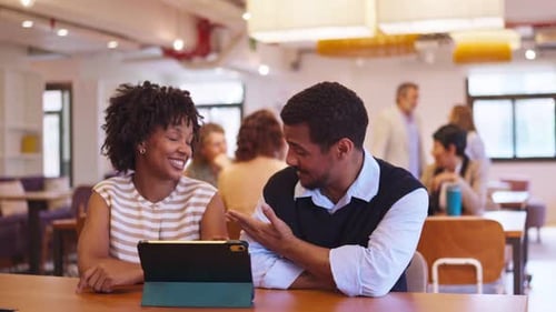Colleagues Collaborating on Tablet Computer in Modern Coworking Office