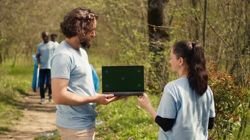 Team of Climate and Nature Activists Using Laptop with Greenscreen Near a Forest