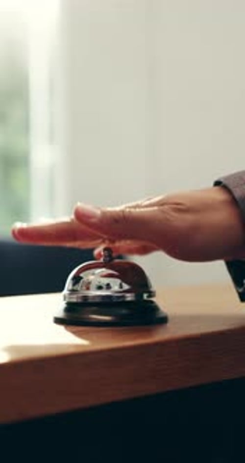 Person, hands and ring with bell for service, customer help or assistance on counter in hotel