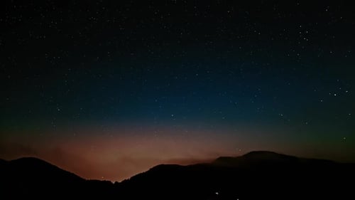 Starry Sky over Silhouetted Mountain Landscape at Night