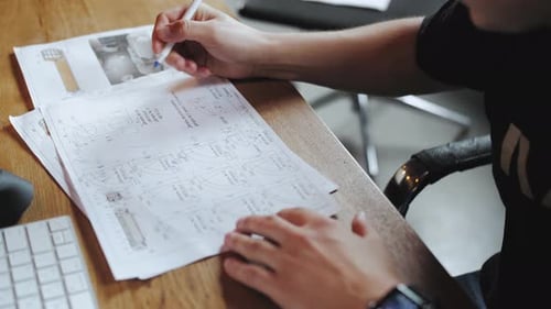 Technical Review: Engineer Marking Blueprints at Desk