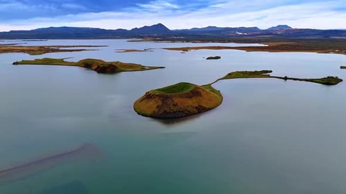 Little islands covered with moss in the calm waterscape. Iceland scenery from top.