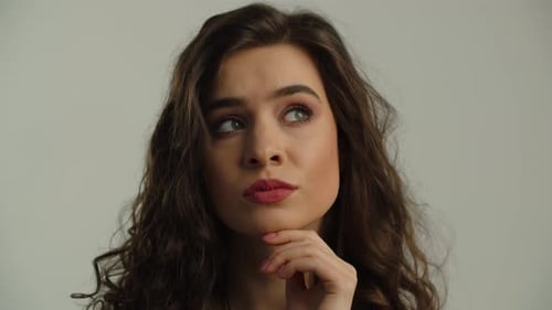 An Attractive Young Brunette is Standing in Front of the Camera and Thinking About Something A