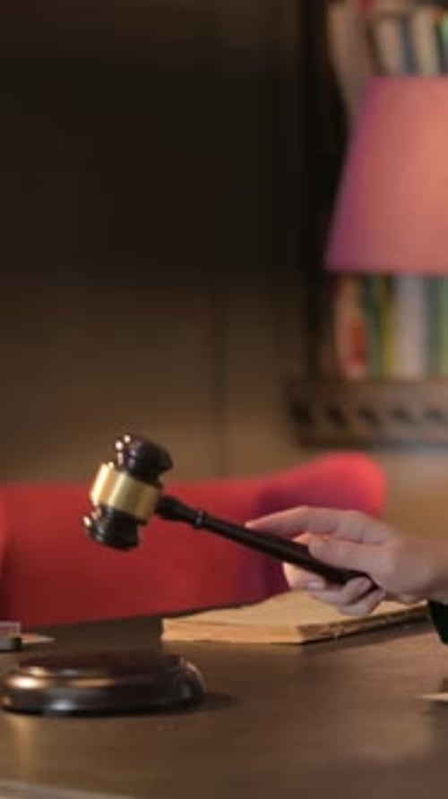 Jueza golpeando un mazo para anunciar la sentencia, vídeo vertical