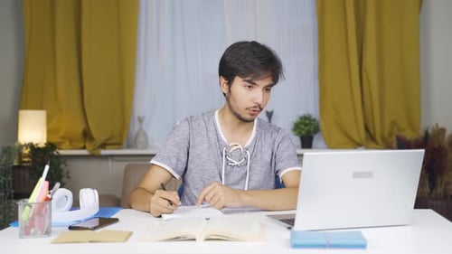 Young Adult Male Works at Home Office