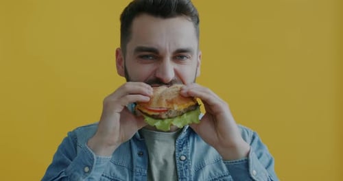 Bearded Man Enjoying a Large Hamburger Close Up