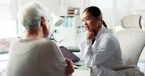 Female Doctor Explains Information to Senior Patient