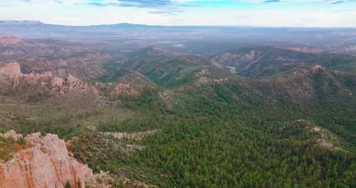 Mountainous panorama on cloudy daytime. Drone footage over the rocky landscape overgrown