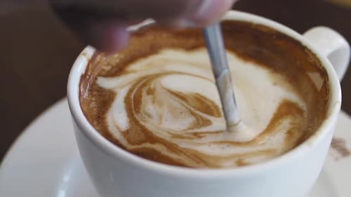 Swirling Coffee Art in a Cozy Cafe Setting