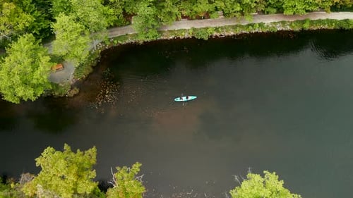 Aerial View of a Forest with a River and Kayaks Floating in the Forest in Summer