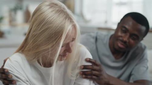 Crying Woman Comforted by Man in Domestic Setting