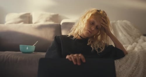Sad Tired Blonde Girl Closes Laptop and Gets Up Near the Sofa Late at Night