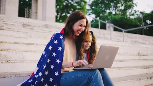 Woman and Child with American Flag Using Laptop