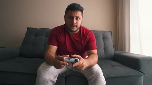Man Playing Video Game on Couch Indoors