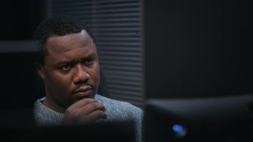 Man Stares at Computer Screen, Takes Off Glasses