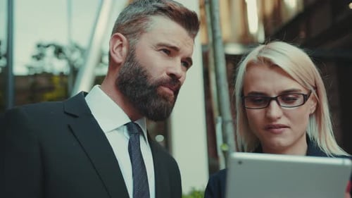 Business People Discussing Work on a Tablet Outside