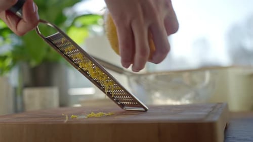 Zesting a Lemon with a Grater in Kitchen