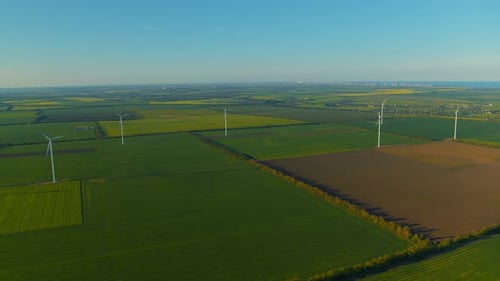 Impressive wind turbines in green fields generating renewable eco energy saving environment