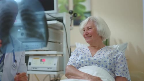 Doctor Discusses X-Ray with Elderly Patient in Hospital