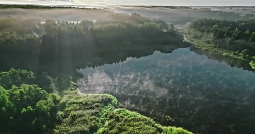 Aerial view of foggy valley with autumn river at sunrise.