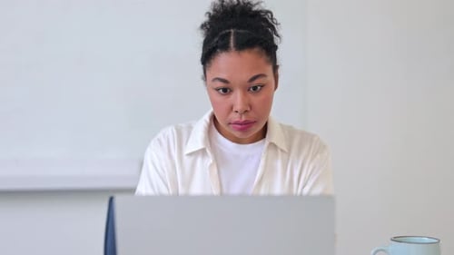 Young Woman Working on Laptop in Bright Room