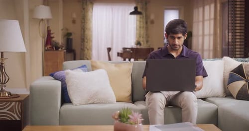 Un Indien ambitieux adopte le travail à distance sur ordinateur portable en tant que designer indépendant, naviguant habilement