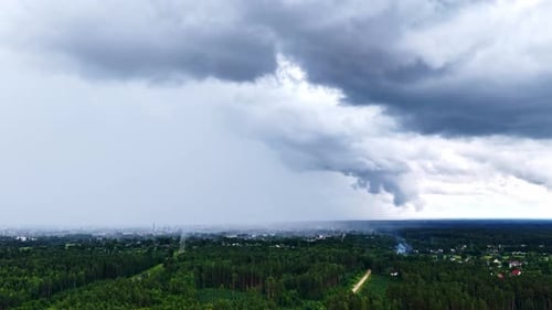 Aerial View of Forests and City Under Stormy Clouds