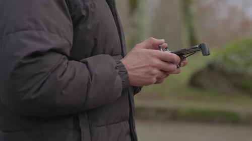 Man Operating Drone Controller Outdoors in Urban Setting