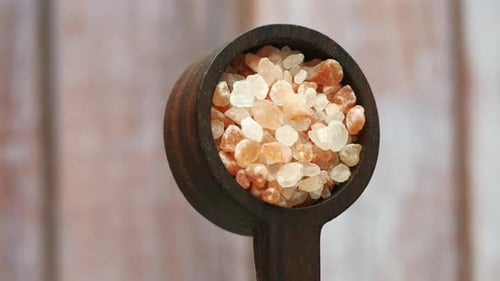 Wooden Spoon Holding Crystals of Pink Salt