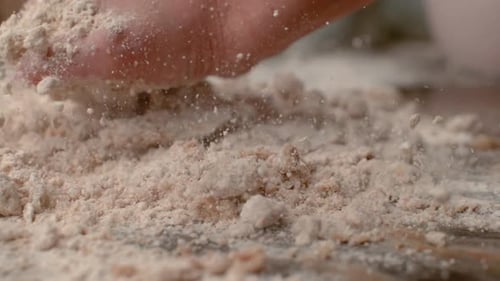 Woman's Hand Mixing Flour on Tabletop