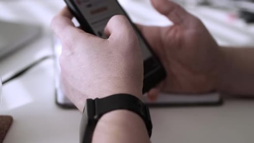 Hands Scrolling on Smartphone with Smartwatch