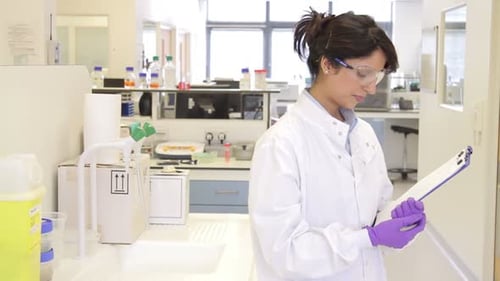 Focused Woman Doctor Writing on Clipboard in Lab