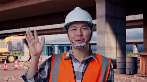 Close Up Of Male Engineer Smiling To Camera And Waving Hand Saying Bye At Building Site