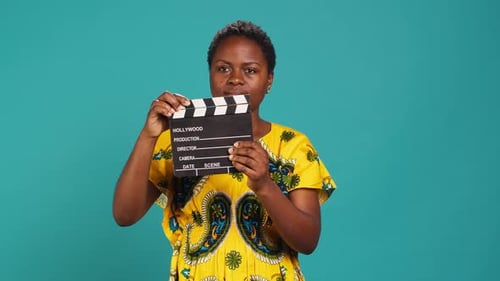 Young Woman Movie Producer Clapping Filming Slate to Cut a Scene